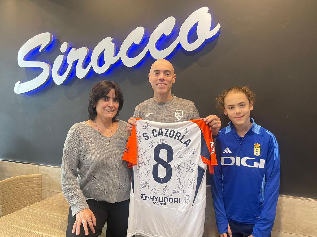 El Tapin - Daniel Burón se llevó la camiseta firmada por todos los jugadores del Real Oviedo, que sortearon el Sirocco Coffee and Bar y la ONG Enlazando Vidas